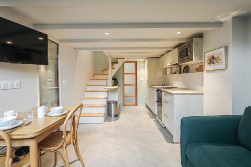 uma sala de estar com uma mesa e uma cozinha com uma escada em Beautiful and bright duplex nearby Alesia - Paris - Welkeys em Paris