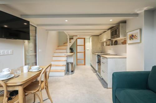 Il comprend un salon avec une table et une cuisine avec un escalier. dans l'établissement Duplex d'Alesia - Paris - Welkeys, à Paris