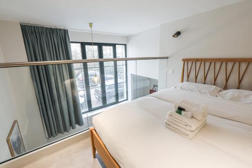 une chambre avec deux lits et une grande fenêtre dans l'établissement Duplex d'Alesia - Paris - Welkeys, à Paris