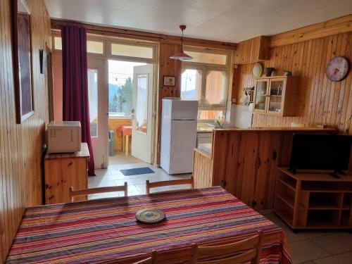 a kitchen with a table and a refrigerator at La Rotonde des Grânes in La Bâtie-Neuve