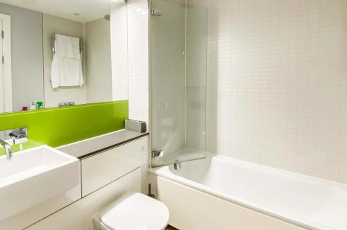 a bathroom with a toilet and a sink and a bath tub at Arcus Apartment 33 in Leicester