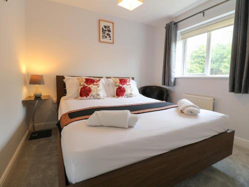 a bedroom with a large bed with a window at 24 Via Devana in Swadlincote