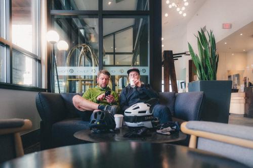 two men sitting on chairs in a room with a table at Aava Whistler Hotel in Whistler