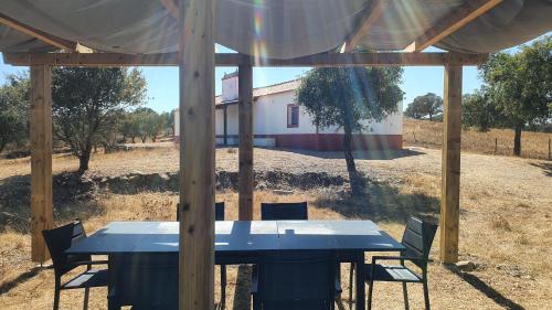 a blue table and chairs under a gazebo at Monte da Clareira - Comporta Carvalhal Melides in Grândola