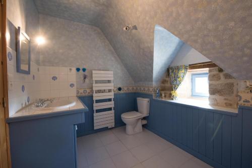 uma casa de banho azul com um lavatório e um WC em maison bretonne em Guidel
