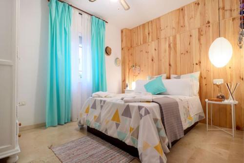 コルドバにあるSlow Home San Fernandoのベッドルーム1室(青いカーテン付きの大型ベッド1台付)