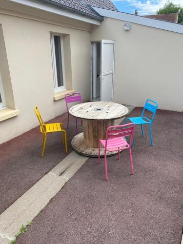 a group of chairs around a table and a table and chairs at Maison calme et confortable in Vaudricourt