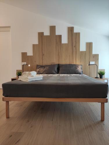 a large bed with a wooden headboard in a room at La Promessa in Santa Maria Nuova