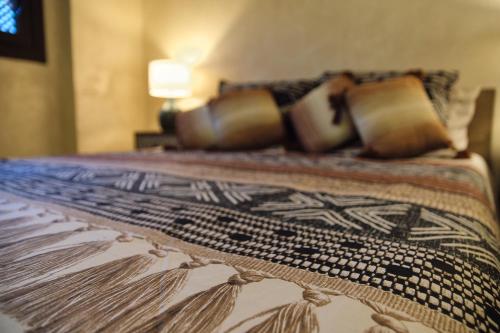 a bed with pillows and a blanket on it at Riad Medina Mudéjar Cádiz in Chiclana de la Frontera