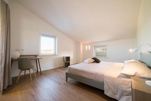 a bedroom with a bed and a desk in it at La Promessa in Santa Maria Nuova