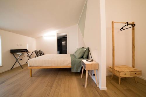 a bedroom with a bed and a desk in a room at La Promessa in Santa Maria Nuova