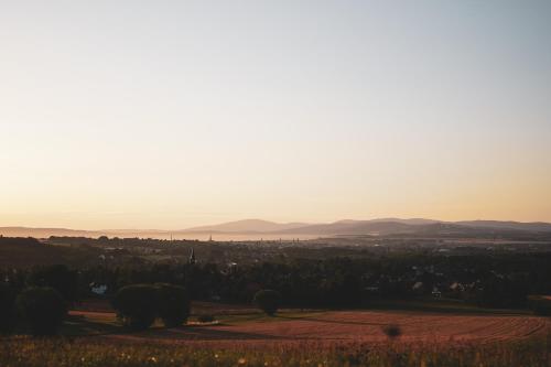 a view of a field with the sunset in the background at Studio Apartment zur alten Post, 48qm Individualapartment mit Blick über Zittaus Altstadt, Ferienwohnung im Altstadtkern umrandet vom Zittauer Gebirge in Zittau