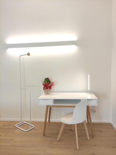 a white desk with a chair and a lamp at La Promessa in Santa Maria Nuova