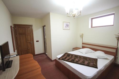 a bedroom with a bed and a chandelier at Casa Teju in Slănic