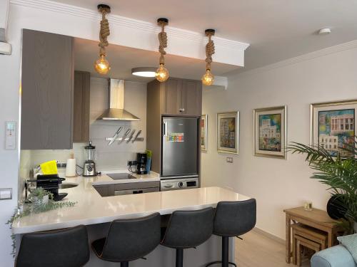 a kitchen with a counter and some chairs in it at La Cala Holiday Retreat in La Cala de Mijas