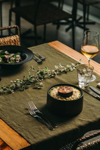 a table with a plate of food and a glass of wine at Santa Barbara Eco-Beach Resort in Ribeira Grande