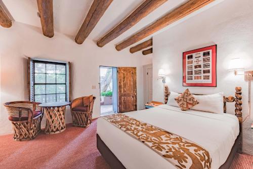 a bedroom with a bed and chairs in a room at The Historic Taos Inn in Taos