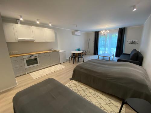 a bedroom with a bed and a kitchen with a table at Captain's House - Kaptenimaja - Apartments in Kärdla