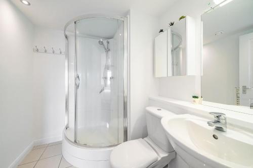 a bathroom with a shower and a toilet and a sink at Quayside Apartment in Dundee