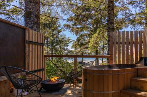 a hot tub on a deck with a table and chairs at Mackenzie Beach Resort in Tofino