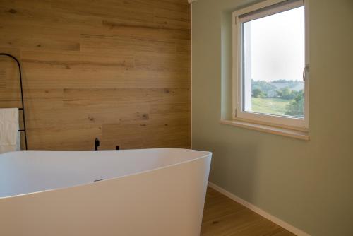 a white bath tub in a room with a window at La Promessa in Santa Maria Nuova