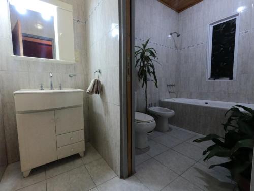 y baño con lavabo, aseo y bañera. en Depto LA QUILMES en Concepción del Uruguay