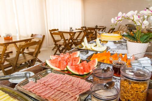 a table with a bunch of food on it at Na Praia Hotel in Porto Seguro