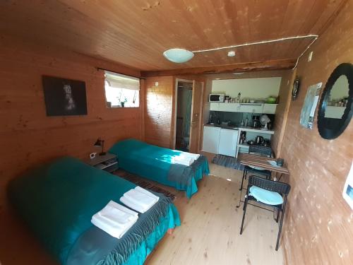 une petite chambre avec deux lits et une cuisine dans l'établissement Knutstorp Ranch, à Tyringe