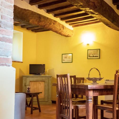 a dining room with yellow walls and a table and chairs at Agriturismo Casal Cerqueto in Canalicchio
