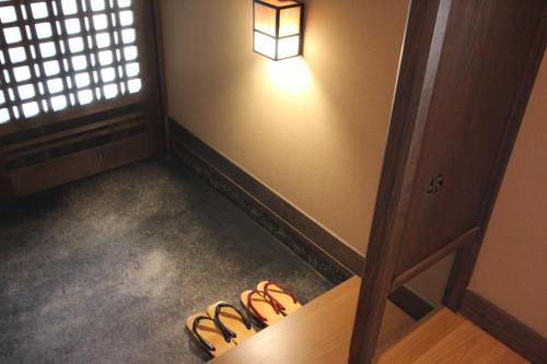 a room with a light and a group of shoes at Ryokan Konomama in Minami Aso