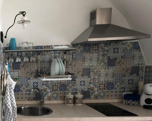a kitchen with a sink and a stove at Il Dammuso dei Sogni in Modica