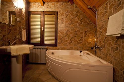 ein Badezimmer mit einer großen Badewanne und einem Waschbecken in der Unterkunft Villa Đurić Superior in Zlatibor
