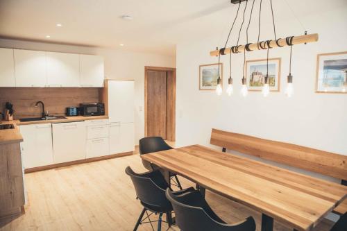 cocina y comedor con mesa de madera y sillas en Haus Schwangau en Schwangau