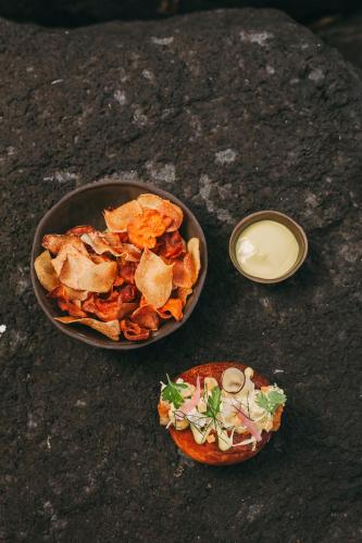 a bowl of food on a table with a plate of food at White Exclusive Suites & Villas in Lagoa