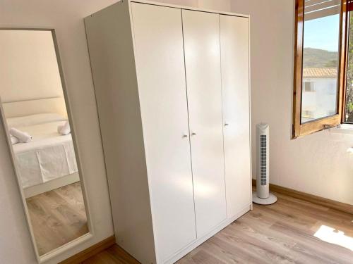a bedroom with a white cabinet and a mirror at Modern apartment with parking 2 min from the beach in Calella de Palafrugell