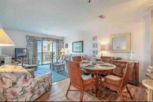 a living room with a table and a couch at Lovely 2-bedroom condo with pool in Myrtle Beach