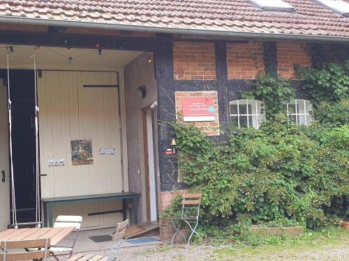 a brick house with a wooden door and a table at Adelheidshof in Magelsen