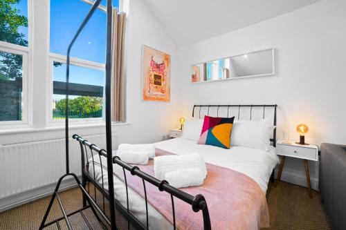 a bedroom with a bed and a window at The Village Coach House in Cardiff