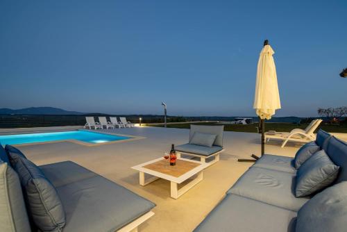 a patio with a couch and a table and a pool at Villa Panorama in Buzet