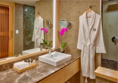 La salle de bains blanche est pourvue d'un lavabo et d'un miroir. dans l'établissement Galeria Plaza Irapuato, à Irapuato