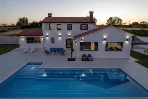a villa with a swimming pool in front of a house at Villa Panorama in Buzet