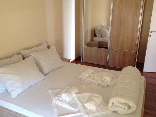 a white bed with towels on it in a room at Apartments Jelušić in Budva