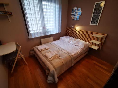 a small bedroom with a bed with a window at Apartament Kraków Arena 20B in Krakow