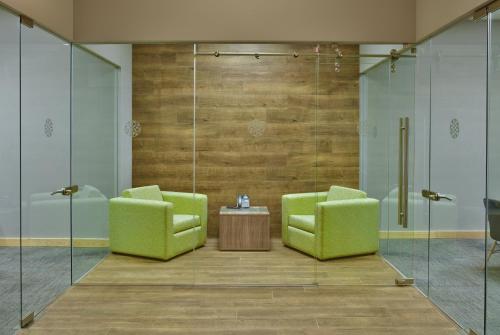 two green chairs and a table in a room at Galeria Plaza Irapuato in Irapuato