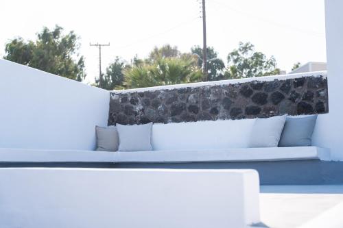 a white bed with pillows on top of a wall at Alme Luxury Cave Villas in Vóthon