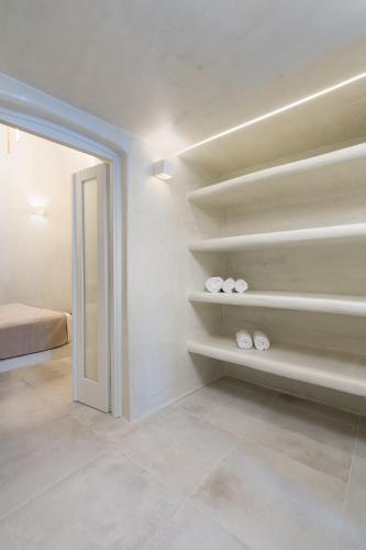 a room with shelves with shoes and a bed at Alme Luxury Cave Villas in Vóthon