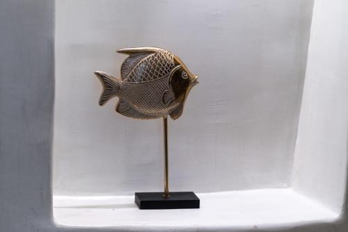 a metal fish on a stand in a display case at Alme Luxury Cave Villas in Vóthon