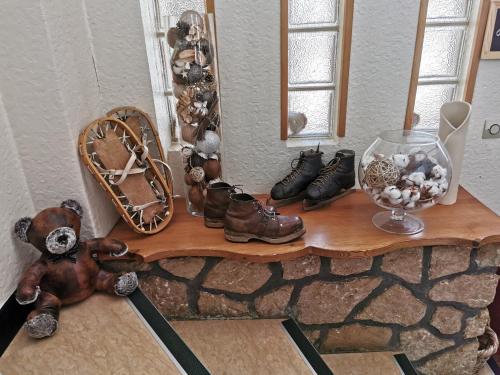 a shelf with a bunch of shoes and a mirror at Hôtel Au Feu De Bois in Autrans