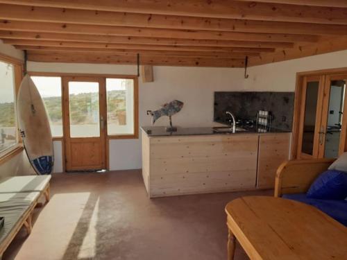 une cuisine avec un évier et un comptoir avec une planche de surf dans l'établissement Dar Nouha : un appartement sur l'océan, à Wassane