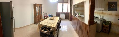 una cucina con tavolo al centro di una stanza di Melvanni a Pomigliano dʼArco